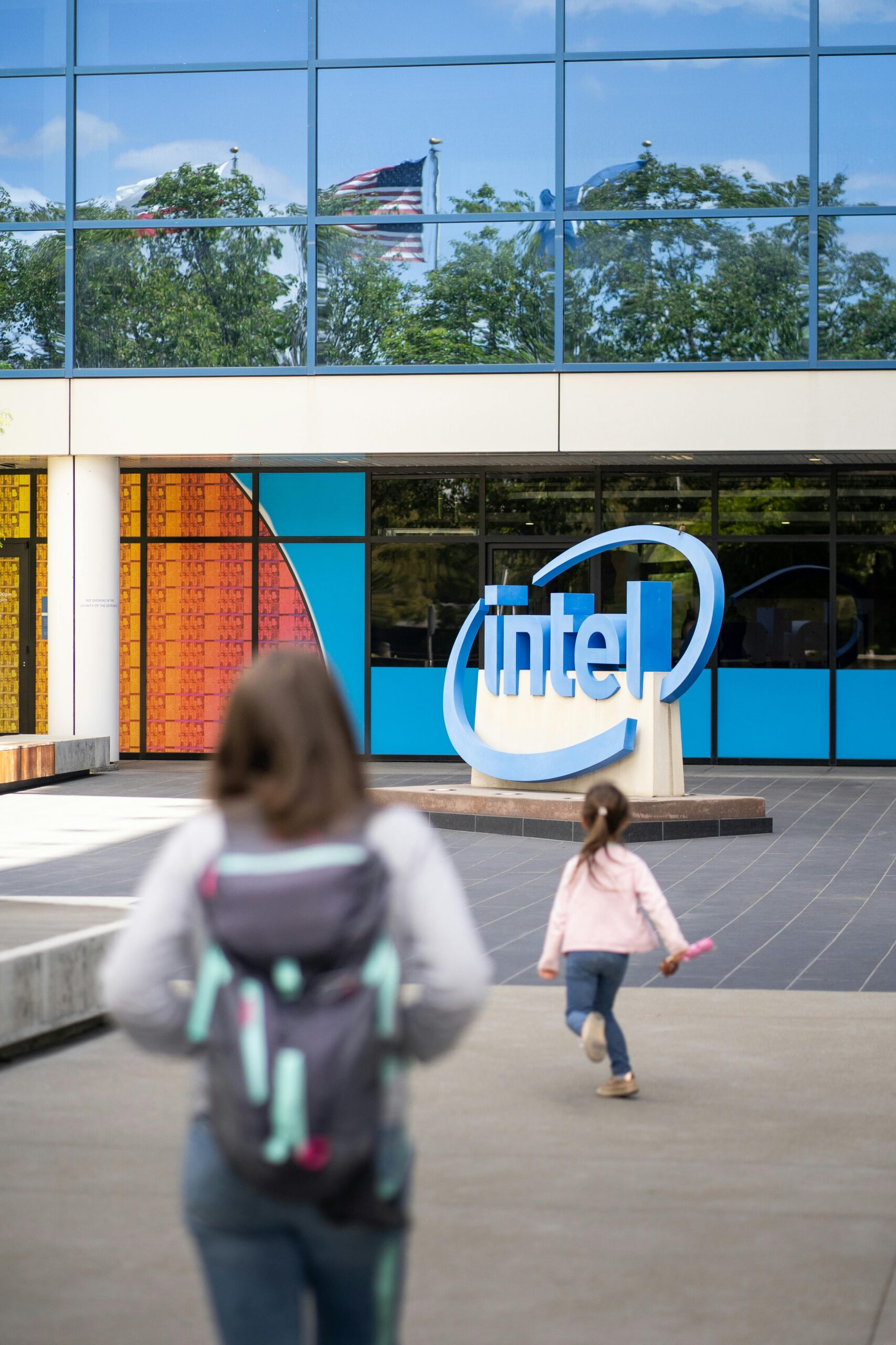 Two individuals outside Intel's San José office building on a sunny day.